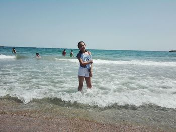 Girl standing on shore at beach