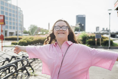 Cheerful teenage girl with arms outstretched having fun