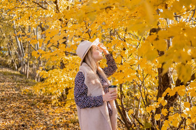 Woman with umbrella in autumn leaves