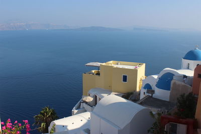 High angle view of buildings by sea against sky