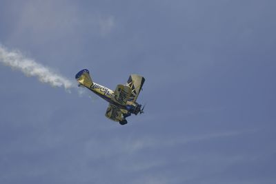 Low angle view of helicopter against cloudy sky