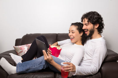 Smiling couple watching video in digital tablet at home