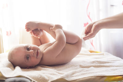 Midsection of woman lying on bed