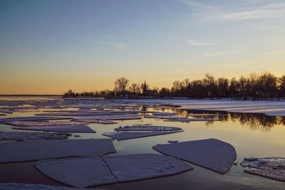 Scenic view of frozen lake against sky during sunset