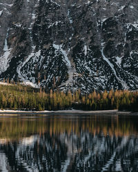 Scenic view of a lake and the reflection of a mountain side and tree line on it