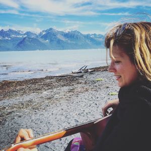 Woman playing guitar on beach