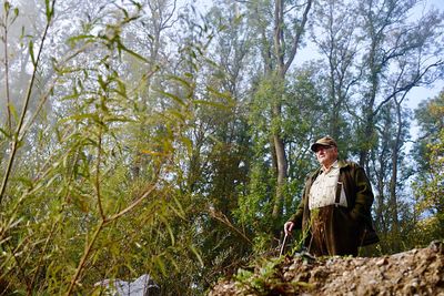 Low angle view of senior man standing in forest