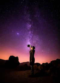 Full length of man standing on rock against sky