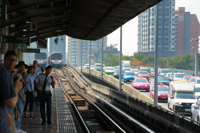 People waiting at railroad station in city