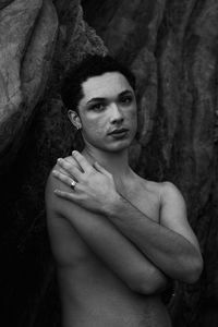 Young male with  androgynous look shot outdoor in black and white with rocks in background.