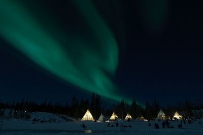 Panoramic view of snowcapped mountains against sky at night during winter