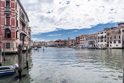 Canal amidst city against sky