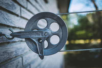 Close-up of metallic pulley on hook over house