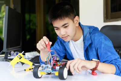 Teenager boy working on robotic toy