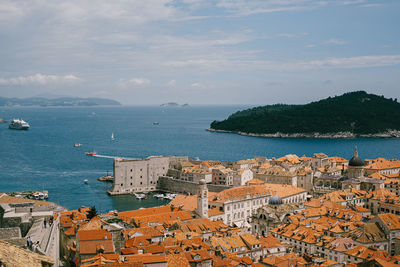 High angle view of townscape by sea against sky