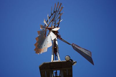 Low angle view of traditional windmill against clear blue sky