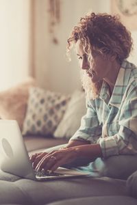 Midsection of woman using mobile phone at home