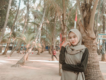 Portrait of young woman standing in park