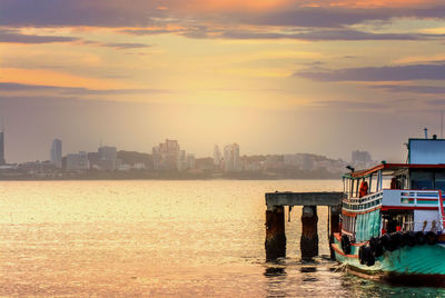 Scenic view of sea and buildings against sky during sunset