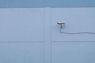 Telephone pole against blue wall and white door