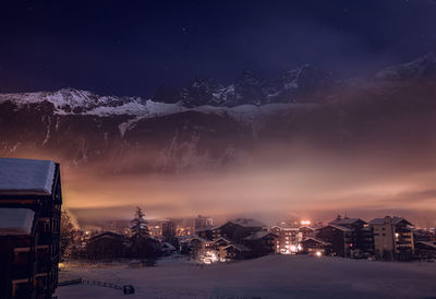 Illuminated buildings against sky at night