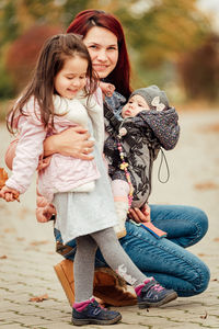 Portrait of happy mother and daughters on land