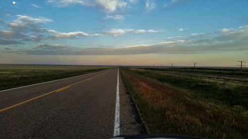 Road by landscape against sky