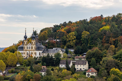 Trees and houses against sky