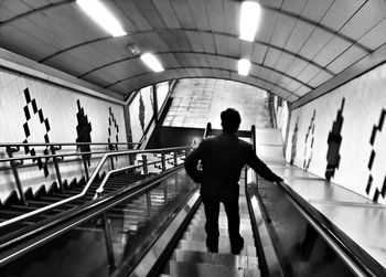 Rear view of man walking on staircase