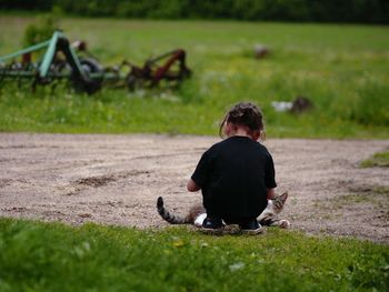 Rear view of man sitting on field