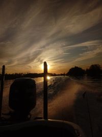 Silhouette car against sky during sunset