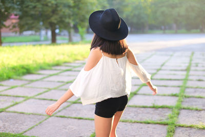 Rear view of woman walking on footpath