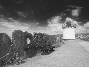 Lighthouse amidst buildings against sky
