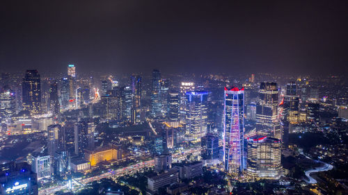 High angle view of city lit up at night