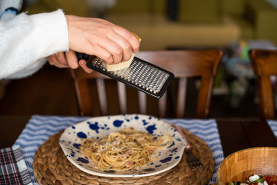 Midsection of person holding ice cream in restaurant