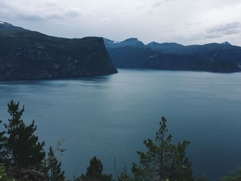 Mountain range and dark blue waters in a fjord, aerial view, nordic landscape, blue tones 