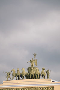 Low angle view of angel statue against sky