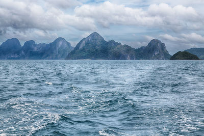 Scenic view of sea and mountains against sky