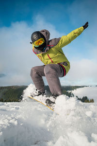 Low angle view of man skiing on snow covered field