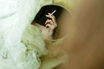 Reflection of woman holding cigarette