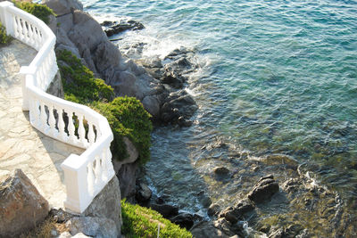 High angle view of rocks by  mediterranean sea waves