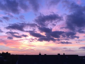 Silhouette city against sky during sunset