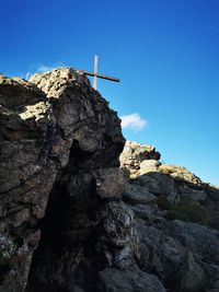 Low angle view of rocky mountain against clear blue sky