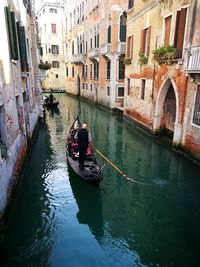 Rear view of people on boat in canal