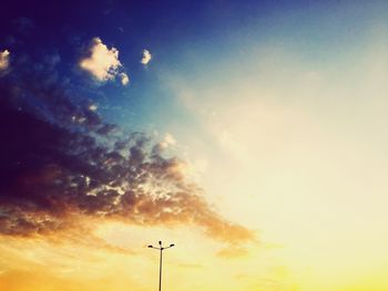 Low angle view of silhouette communications tower against sky during sunset