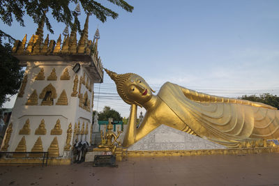 Statue against temple building against sky