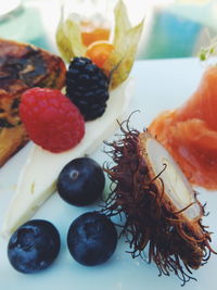 Close-up of fruits and smoked salmon in plate
