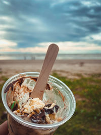 Close-up of drink in glass container on land against sky