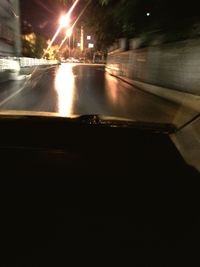 Illuminated street seen through car windshield