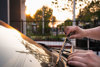 Cropped hands of person adjusting windshield wiper